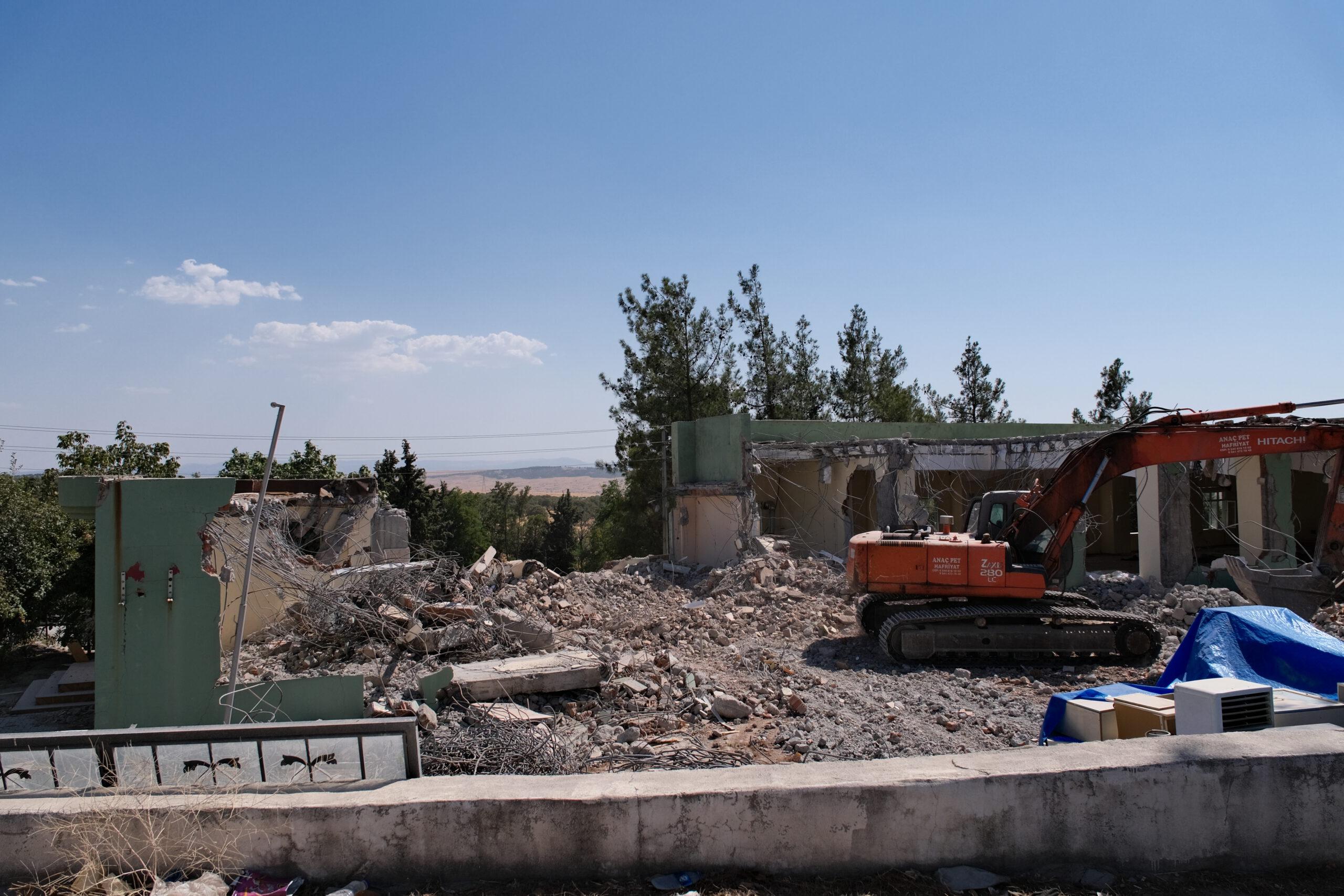 Ein Bagger arbeitet an einem Haus in der Türkei, das durch das Erdbeben eingestürzt ist.