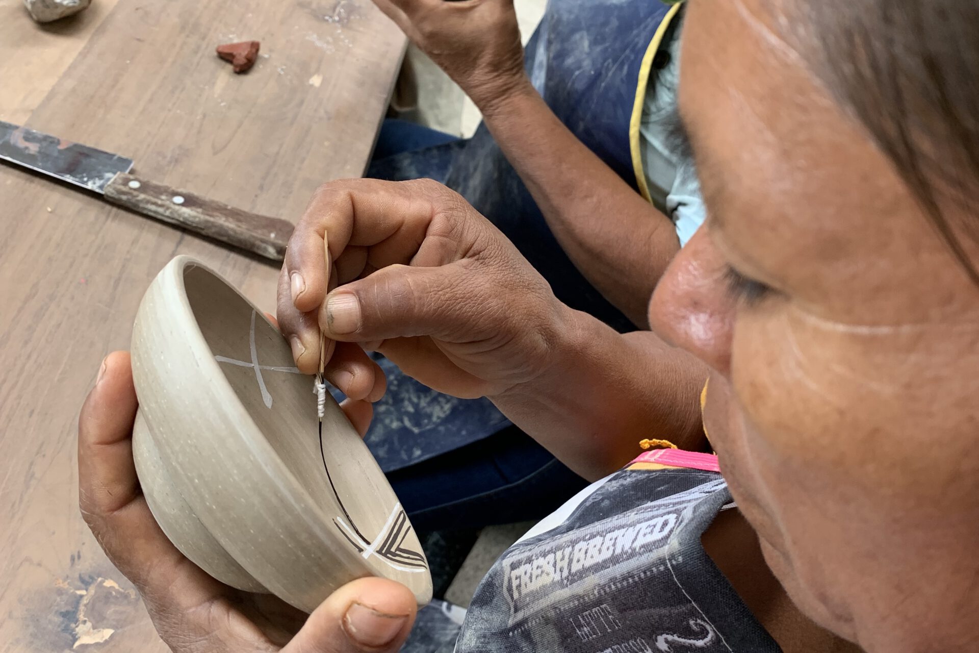 Eine Frau bemalt eine Keramikschüssel