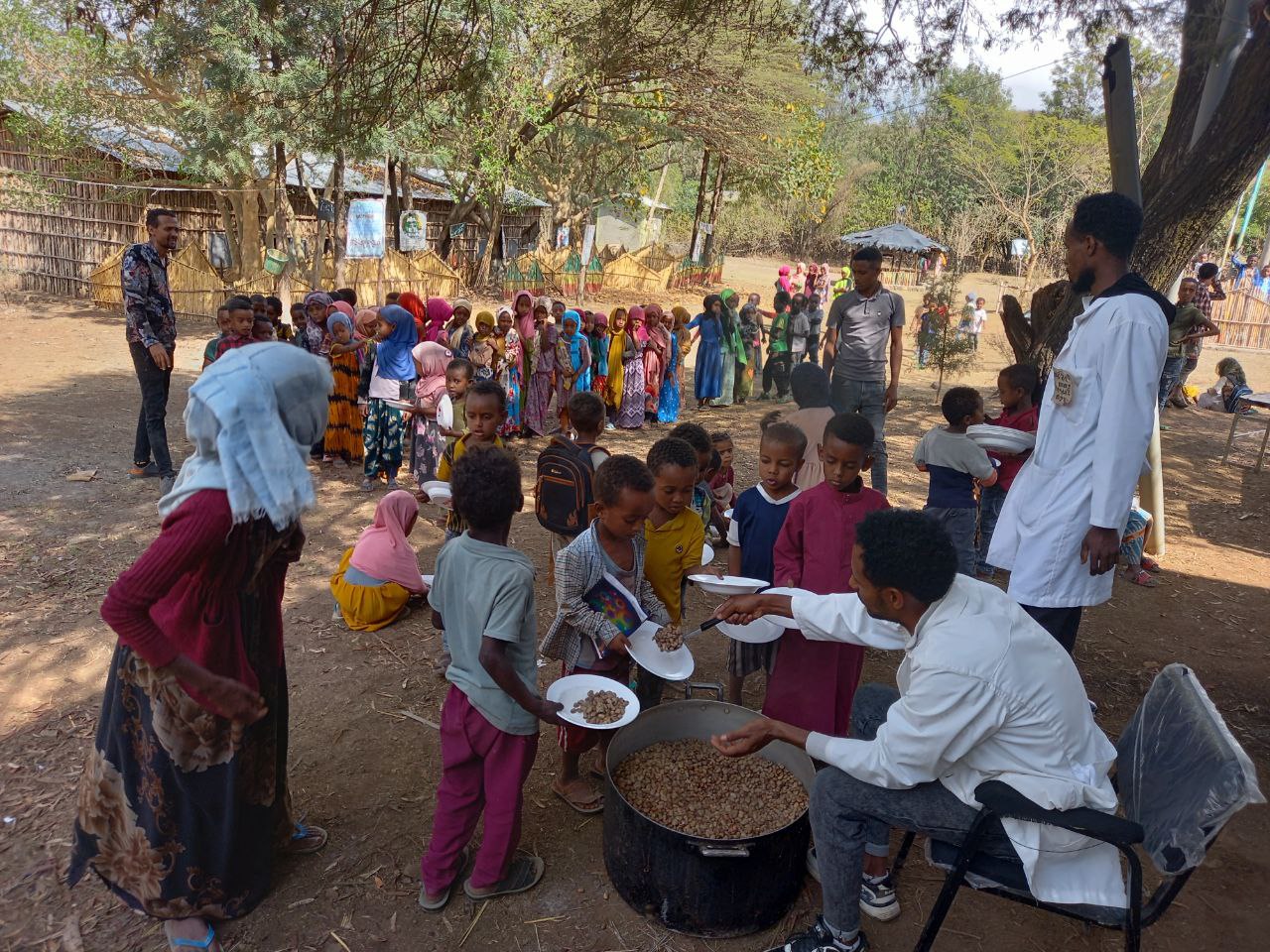 Schulmahlzeiten gegen den Hunger: Ein Mann gibt Kindern Essen aus